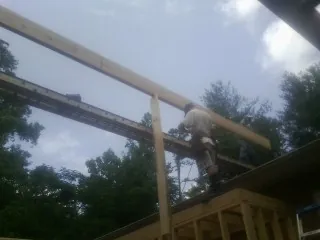 Carpenter setting a ridge beam over a new addition frame — Ice Dam Removal by Roofing Brothers in Anaconda