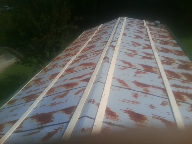 Rusted metal roof panels with new wood purlins before replacement — Storm Damage Roof Repair in Anaconda by Roofing Brothers