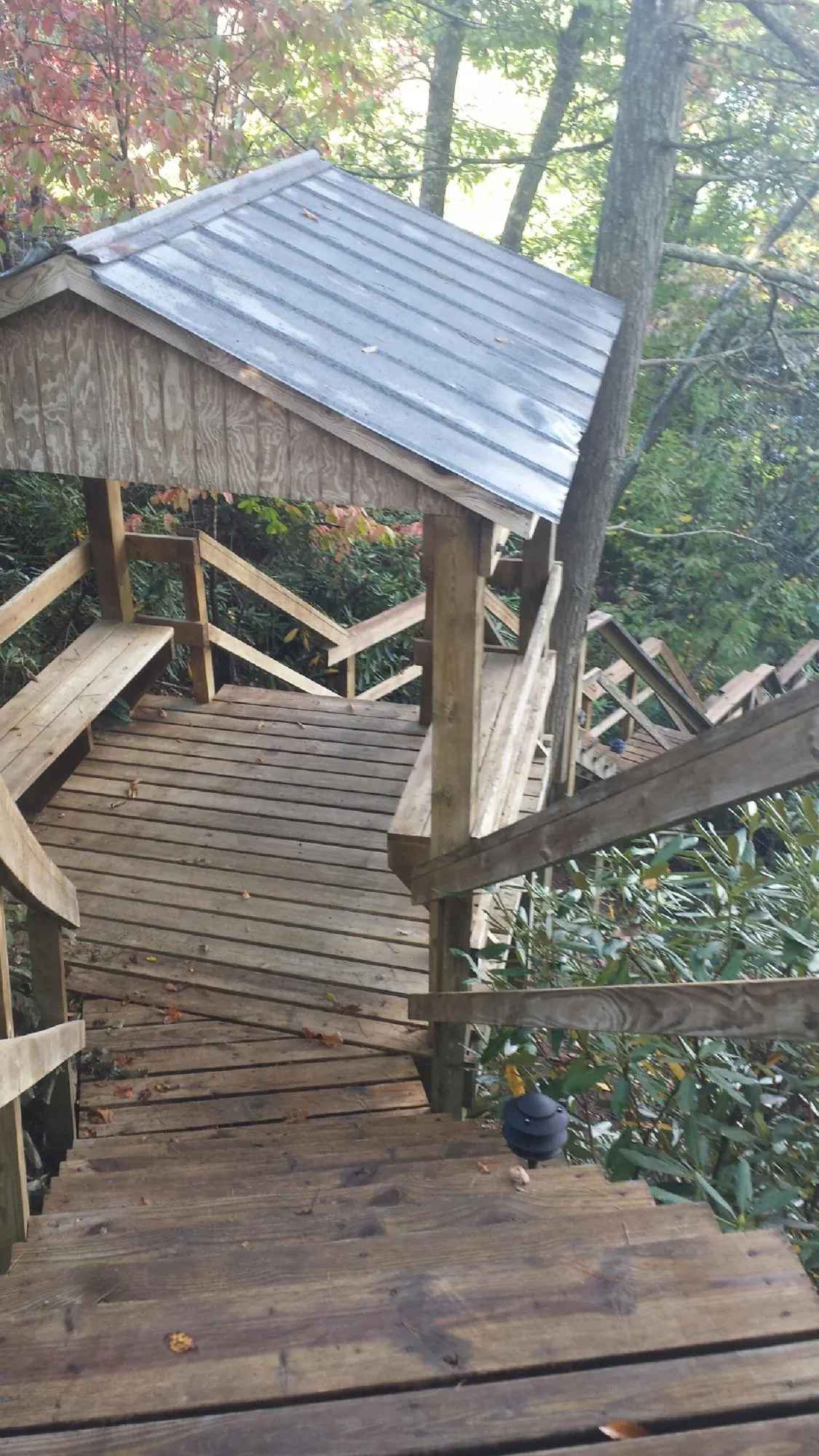 Metal roofed shelter over wooden steps on a wooded walkway — Skylight Repair & Installation work by our crew in Anaconda