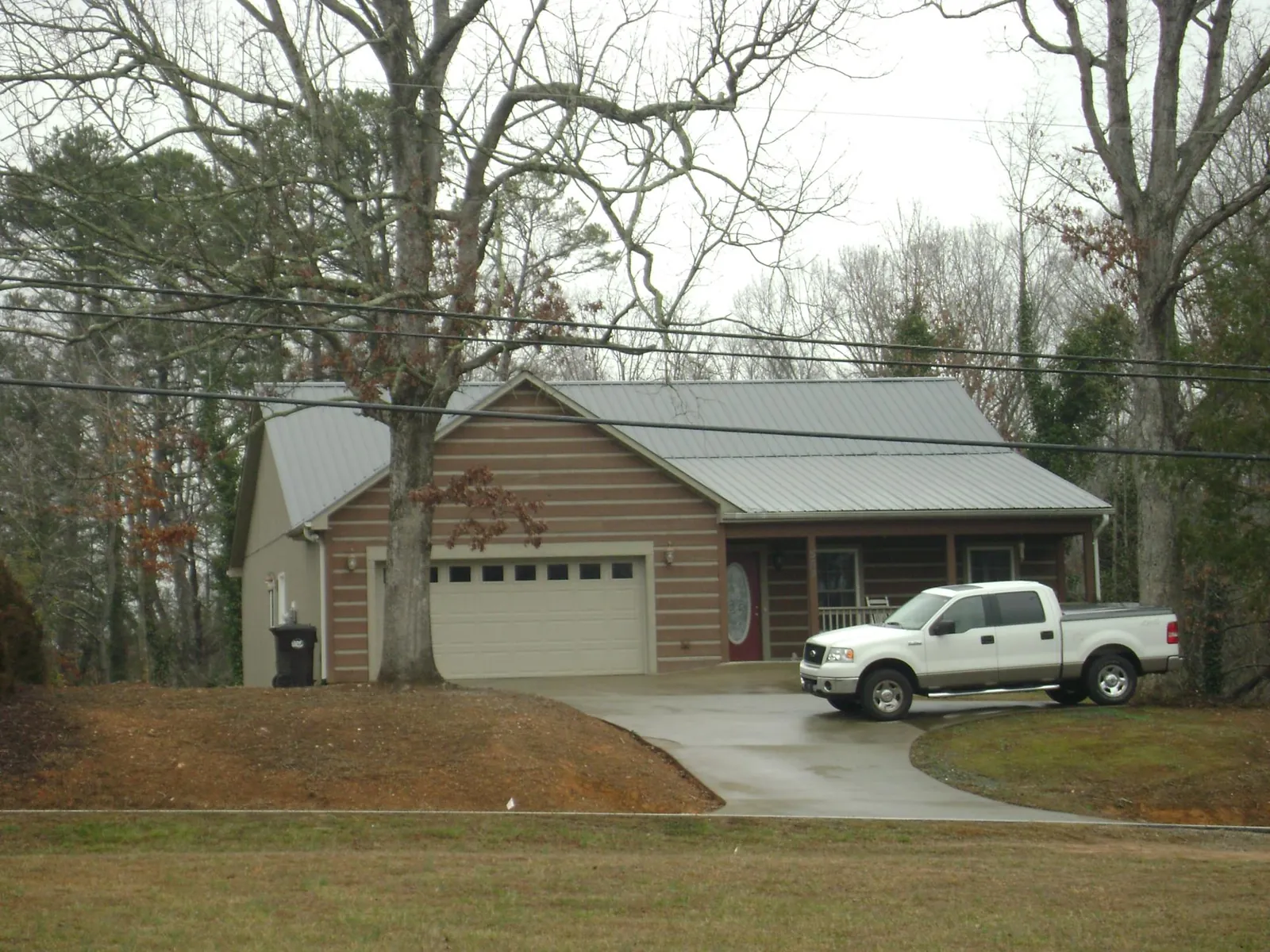 Gray metal roof on a log sided house with an attached two car garage in Anaconda